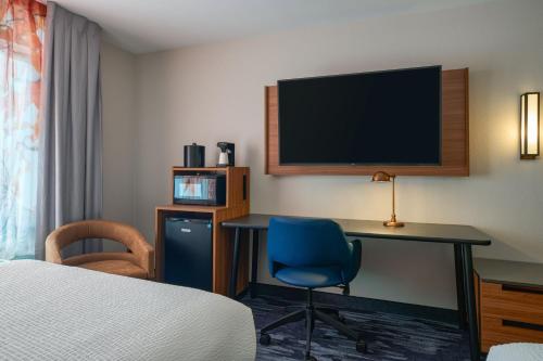 a hotel room with a desk and a tv at Fairfield Inn and Suites by Marriott Winchester in Winchester