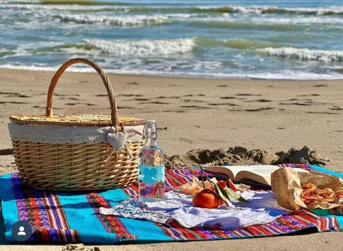 a picnic blanket with a basket and a bottle on the beach at Villa Teresa in Ginosa Marina