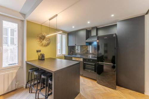 uma cozinha com um frigorífico preto e um balcão em Chez Antho T4 - appart T4 moderne en plein cœur du Panier em Marselha