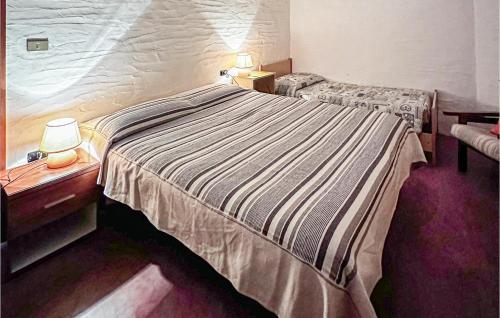 um quarto com uma cama grande e 2 candeeiros nas mesas em Stunning Home In Orgosolo With Wifi em Orgosolo