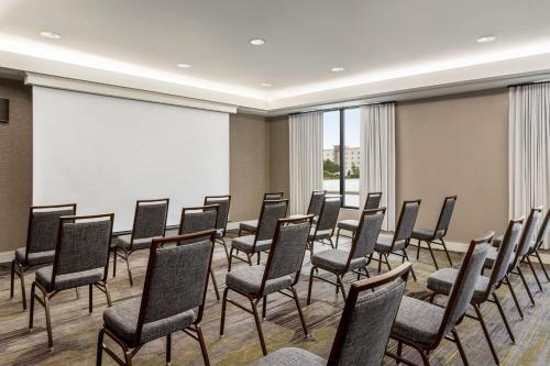 a conference room with chairs and a large screen at Courtyard Tupelo in Tupelo