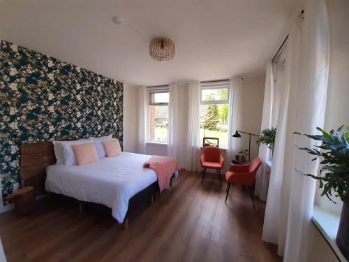 um quarto com uma cama e uma parede floral em B&B het Klontje em Vriescheloo