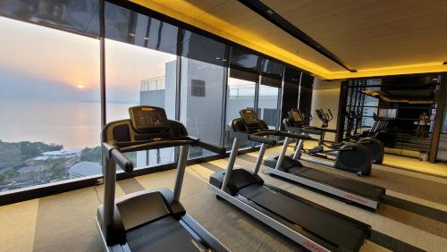 a gym with several cardio machines in a building at Andromeda Seaview Condo Near Beach in Pattaya South