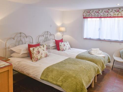 two twin beds in a room with a window at Reedham Retreat in Reedham