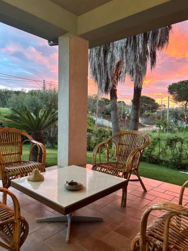 a patio with a table and chairs and a sunset at Alto Giardino in Zambrone
