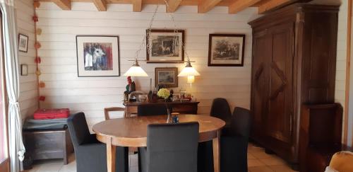 une salle à manger avec une table et des chaises en bois dans l'établissement La maison bois, à Chaon