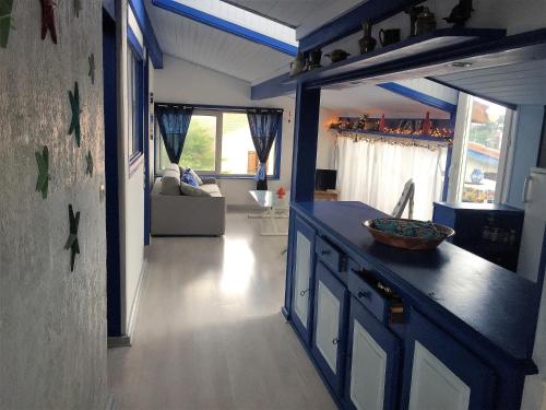 une cuisine avec un comptoir bleu et un salon dans l'établissement sci moliere, à Saint Cyprien Plage