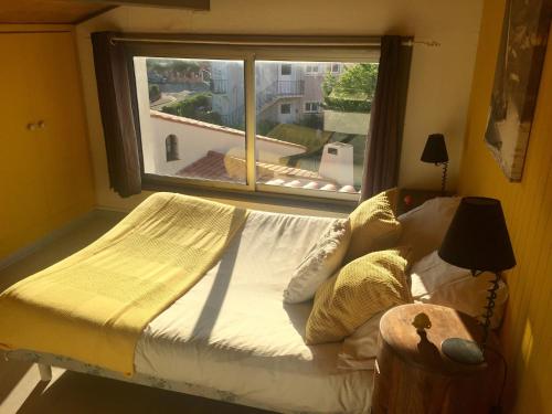 un lit dans une chambre avec une grande fenêtre dans l'établissement sci moliere, à Saint Cyprien Plage