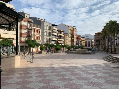 una calle urbana vacía con edificios y palmeras en LOFT LA LUNA, en Villanueva del Arzobispo