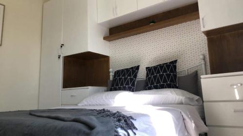 a bedroom with a bed with black and white pillows at Flexi Unit 1BR or 2BR convertible at South Residences Las Pinas in Manila