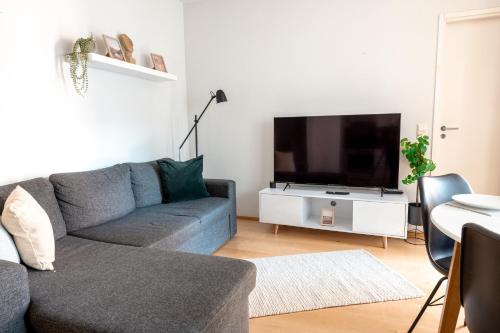 a living room with a couch and a flat screen tv at 2ndhomes Stylish 1BR home with Balcony and Sauna in Kamppi Center in Helsinki