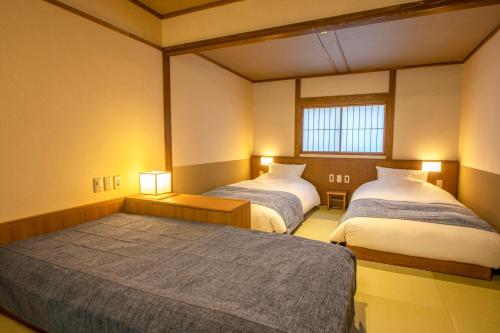 Habitación con 2 camas y 2 lámparas. en Shionoyu Onsen Rengetsu en Nasushiobara