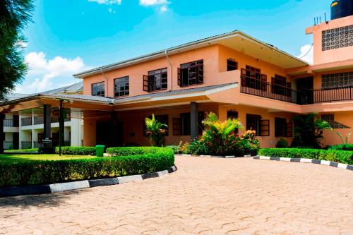 a house with a driveway in front of it at Kalya Courts Hotel Fort Portal in Fort Portal