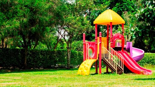 a playground with a slide in the grass at Kalya Courts Hotel Fort Portal in Fort Portal