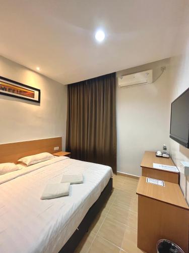 Habitación de hotel con cama y TV en Hotel Premier Inn (Prima Square), en Sandakan