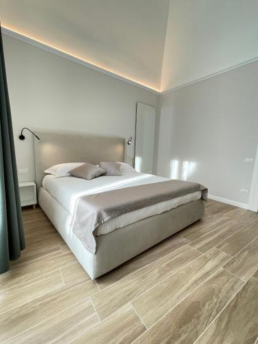een slaapkamer met een groot bed en een houten vloer bij Dimora Savoia in Corato
