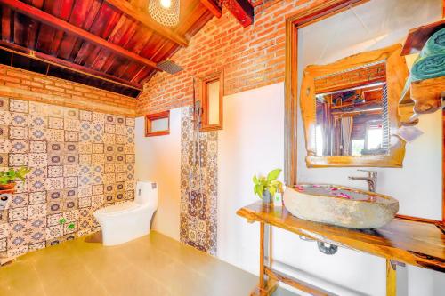 uma casa de banho com um lavatório e um WC em Eco Wooden villa Hoi An em Hoi An
