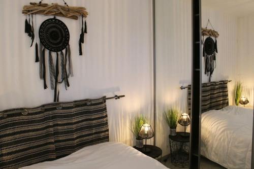 een slaapkamer met een bed en een muur met opgehangen keukengerei bij T1 Cabine 4 couchages vue mer ! in Frontignan