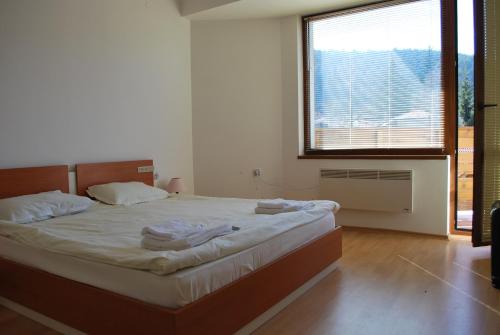 una camera da letto con un grande letto con una grande finestra di PM Services Riverside Apartments a Madzhare