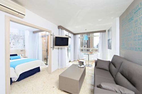 - une chambre avec un lit, un canapé et une télévision dans l'établissement Flamingo Beach Resort - Adults Recommended, à Benidorm