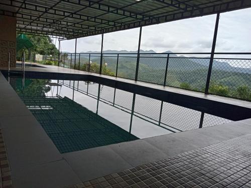 een zwembad met uitzicht op een waterlichaam bij Theeram Agro Farm Hill Resort Vagamon in Vagamon