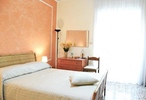 a bedroom with a bed and a dresser and a mirror at B&B Stella in Salerno