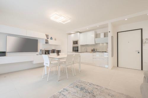 cocina blanca con mesa y sillas en Residence Luxury Elisabeth, en Caorle