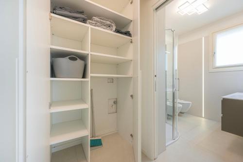 a bathroom with white shelves and a shower at Residence Luxury Elisabeth con garage in Caorle