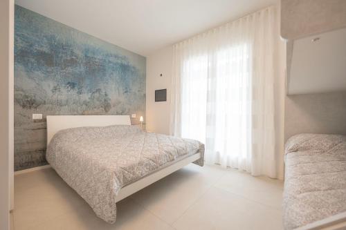 a bedroom with a bed and a large window at Residence Luxury Elisabeth in Caorle