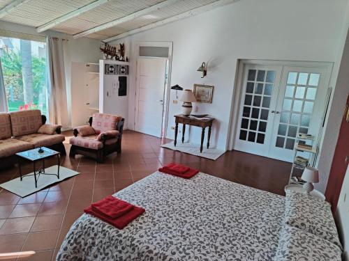 uma grande sala de estar com uma cama e um sofá em Villa Manzella piscina privata em Cinisi