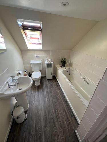 a bathroom with a toilet and a tub and a sink at Oakbank Farm in Lamlash