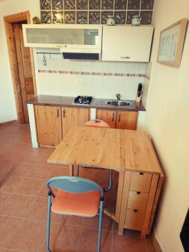 a kitchen with a wooden table and two chairs at Monolocale La Maddalena in La Maddalena