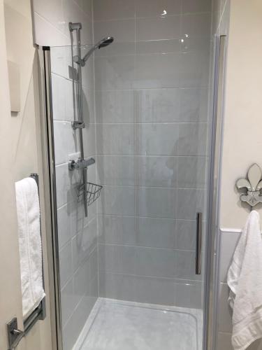 a shower with a glass door in a bathroom at Room in Twemlow Green in Goostrey