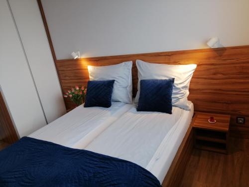 1 dormitorio con 2 camas y almohadas azules y blancas en Apartament71, en Płock