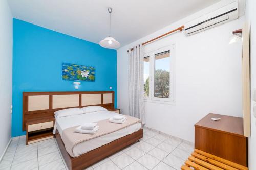 a bedroom with a bed and a blue wall at Troulis Seaside in Amoudara Herakliou