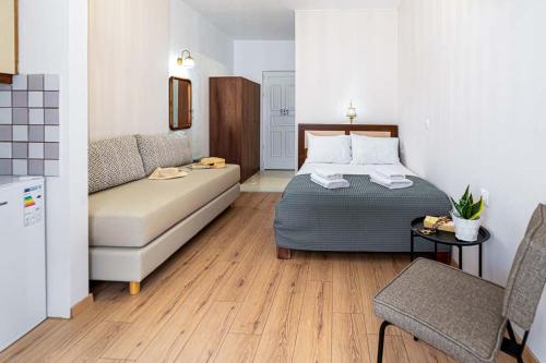a hotel room with a bed and a couch at Troulis Seaside in Amoudara Herakliou