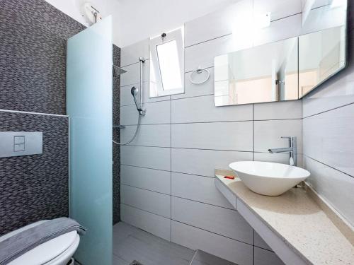 a bathroom with a sink and a toilet and a mirror at Troulis Seaside in Amoudara Herakliou