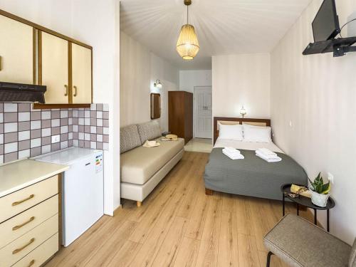 a bedroom with a bed and a couch in a room at Troulis Seaside in Amoudara Herakliou