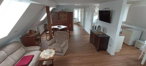 a living room with a couch and a tv at Gemütliche Wohnung am Wald in Loosen