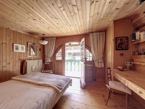 een slaapkamer met een bed en een houten plafond bij Chalet Ardent Montriond 8 personnes in Montriond