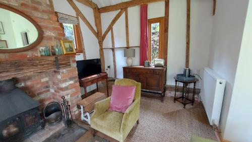 een woonkamer met een stoel en een spiegel bij Brooklands Barn in Lower Swanwick