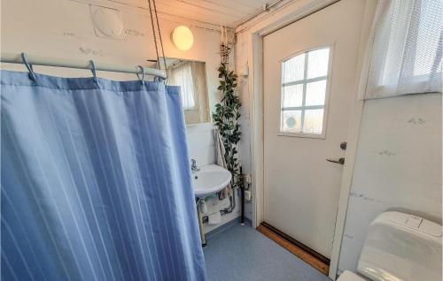 La salle de bains est pourvue d'un rideau de douche bleu et d'un lavabo. dans l'établissement Nice Home In Mellerud With 3 Bedrooms, à Mellerud