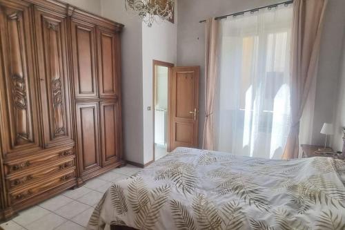 um quarto com uma cama e um grande armário de madeira em Casa Leonardo & Elisa em Figline Valdarno