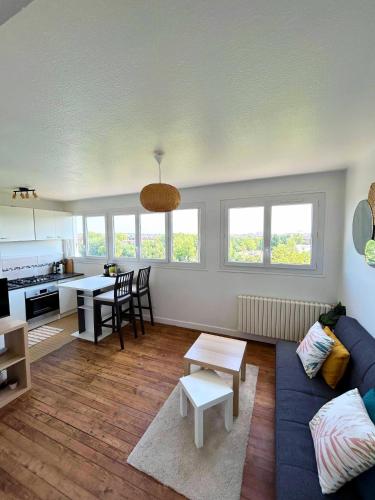 un salon avec un canapé bleu et une table dans l'établissement Vue Garonne - Stadium - Tramway, à Toulouse