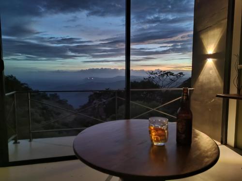 a table with a bottle and a glass on a balcony at GlenMyu Estate in Haputale