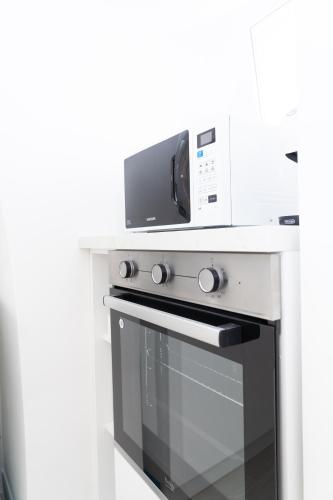 a microwave sitting on top of a stove in a kitchen at Apartment - White Place - Affitti Brevi Italia in Manfredonia