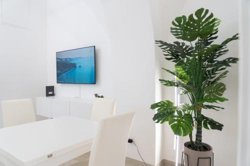 a living room with a white table and a plant at Apartment - White Place - Affitti Brevi Italia in Manfredonia