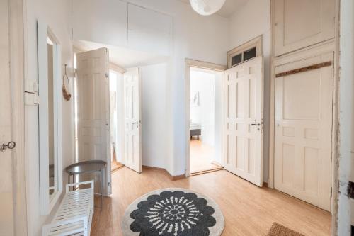 a hallway with white walls and white doors and a rug at 2ndhomes 1BR Apartment in the Center of Helsinki in Helsinki