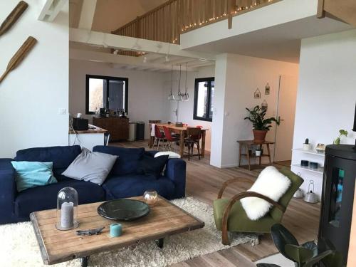 - un salon avec un canapé bleu et une table dans l'établissement Villa vue exceptionnelle sur le Cap Gris-Nez, à Audinghen