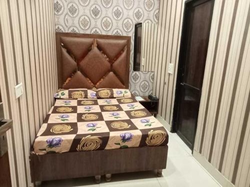 a bedroom with a bed with a quilt on it at Hotel Sunshine in Ludhiana